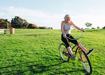Mulher andando de bicicleta, representando uma das medidas que podem ajudar no tratamento da depressão