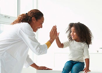 Médica com uma criança, representando o cuidado e a orientação no manejo da epilepsia na infância