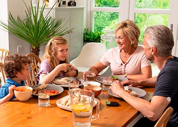 Família tomando café da manhã, destacando a importância de cuidados com a alimentação no verão