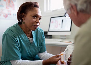 Médica conversando com um idoso, ilustrando a importância do diagnóstico e tratamento do hipotireoidismo